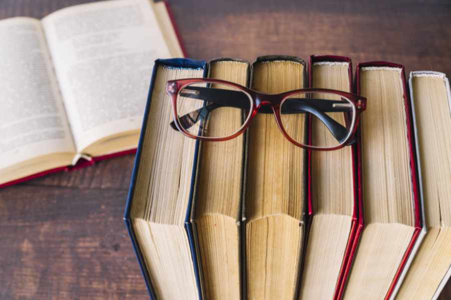 Bücher mit Brille als Symbol für Lektorat und Textarbeit