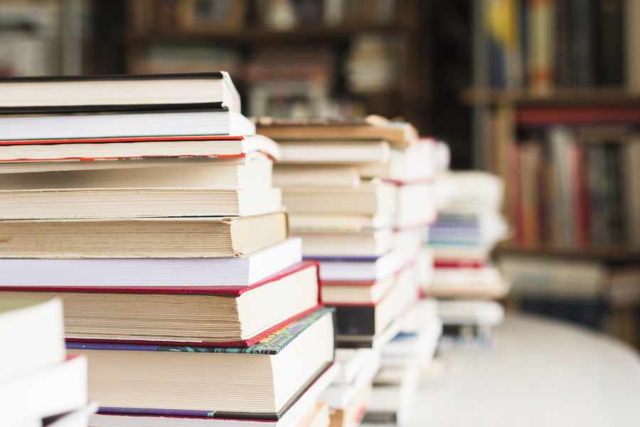 Bücherstapel in Bibliothek als Symbol für Literatur und Manuskripte